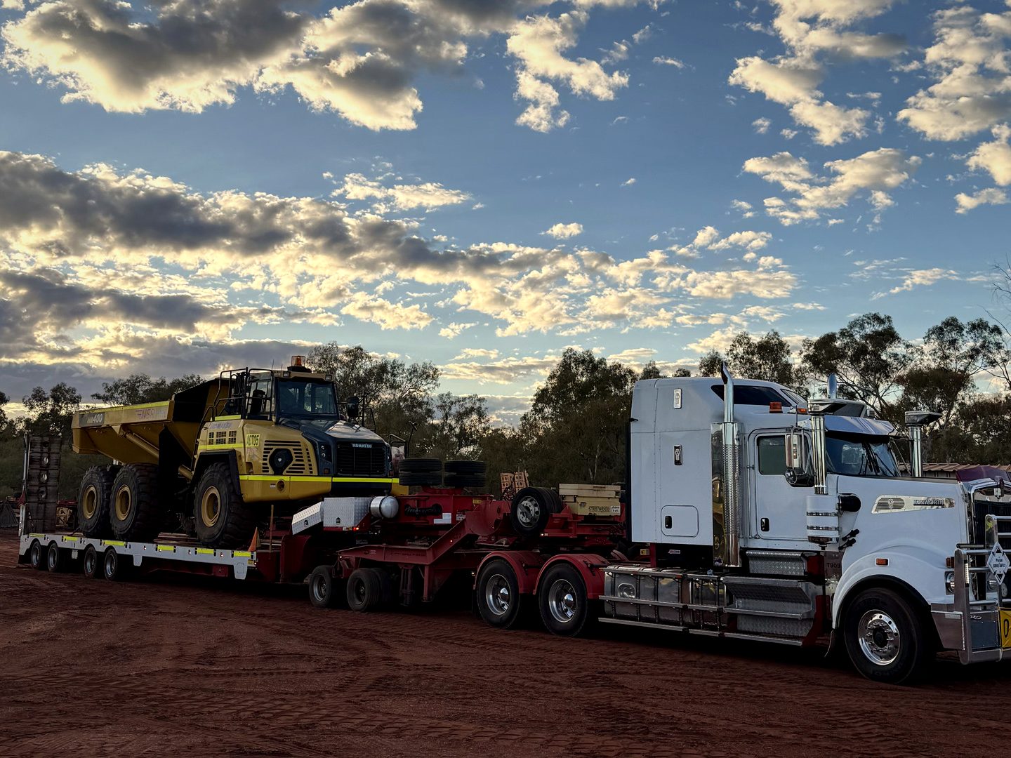 Prime mover hauling heavy plant at dusk